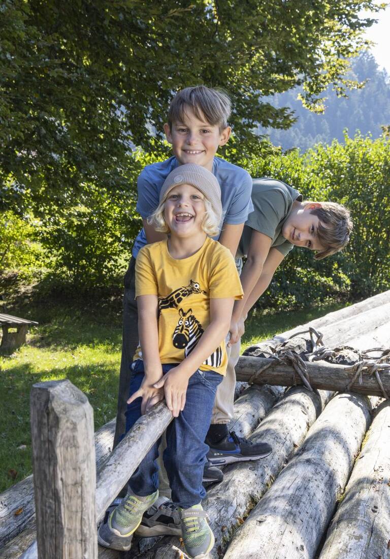 Drei Kinder stehen auf einem Holzfloss